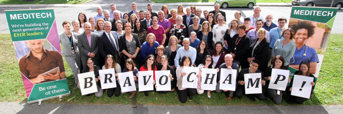 Groupe de gens posant avec des affiches sur lesquelles on peut lire « Bravo CHAMP ».