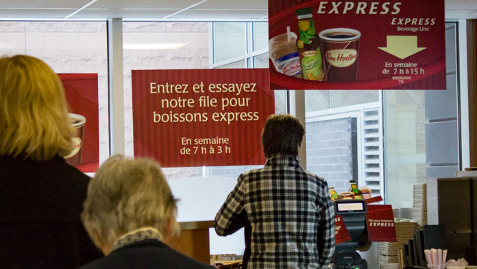 File de gens devant le comptoir de service du Tim Hortons.