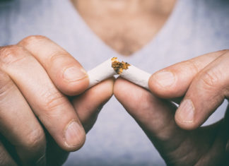 Plan rapproché des doigts qui casse une cigarette en deux.