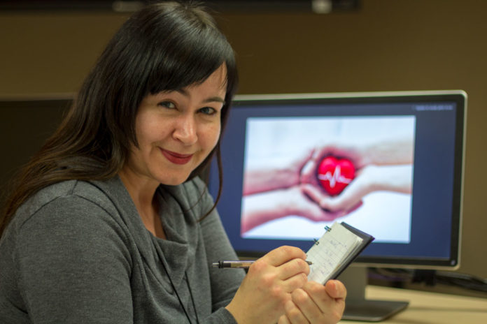 courrier-du-coeur-022018 Femme en train d'écrire dans un cahier, en étant assise devant un écran d'ordinateur.