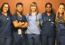 CInq jeunes étudiants en médecine debout