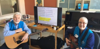 Ça « jam » au troisième Deux hommes avec des guitares