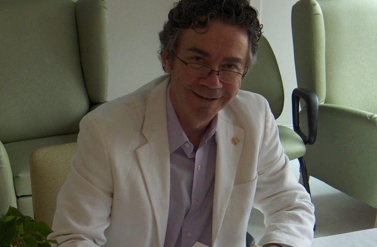 Homme souriant, vêtu d'un saraut blanc