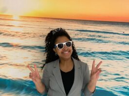 Femme noire avec lunettes de soleil devant une murale