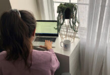 Femme qui tape à son ordinateur portable devant une fenêtre
