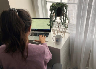 Femme qui tape à son ordinateur portable devant une fenêtre