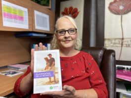 Femme blonde avec chandail rouge qui tient un pamphlet sur la retraite