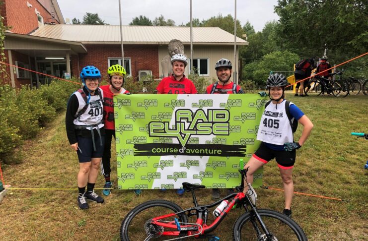 Une gang de physios à l’aventure 5 adultes devant une bannière en équipement sportif