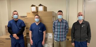 Quatre hommes devant une pile de boîtes en carton