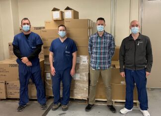 Quatre hommes devant une pile de boîtes en carton