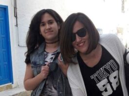 Mère et sa fille souriante devant une porte bleue