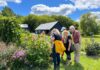 Groupe de personnes en plein air, entourant un buisson de fleurs