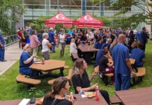 Groupe d'employés de Montfort en train de manger dans la cour intérieure de l'hôpital