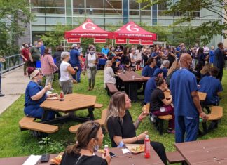 Groupe d'employés de Montfort en train de manger dans la cour intérieure de l'hôpital