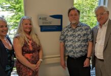 Deux femmes et deux hommes, dont Maitre Ronald Caza, devant la plaque commémorative qu'ils viennent de dévoiler à l'entrée du Centre familial de naissance de Montfort