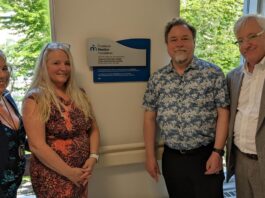 Deux femmes et deux hommes, dont Maitre Ronald Caza, devant la plaque commémorative qu'ils viennent de dévoiler à l'entrée du Centre familial de naissance de Montfort
