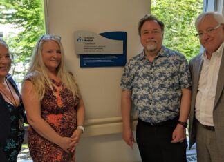 Deux femmes et deux hommes, dont Maitre Ronald Caza, devant la plaque commémorative qu'ils viennent de dévoiler à l'entrée du Centre familial de naissance de Montfort