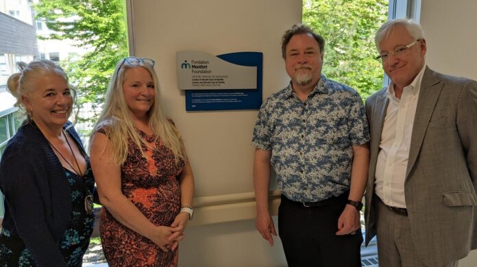 Deux femmes et deux hommes, dont Maitre Ronald Caza, devant la plaque commémorative qu'ils viennent de dévoiler à l'entrée du Centre familial de naissance de Montfort