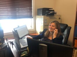Femme au téléphone dans un bureau devant un ordinateur